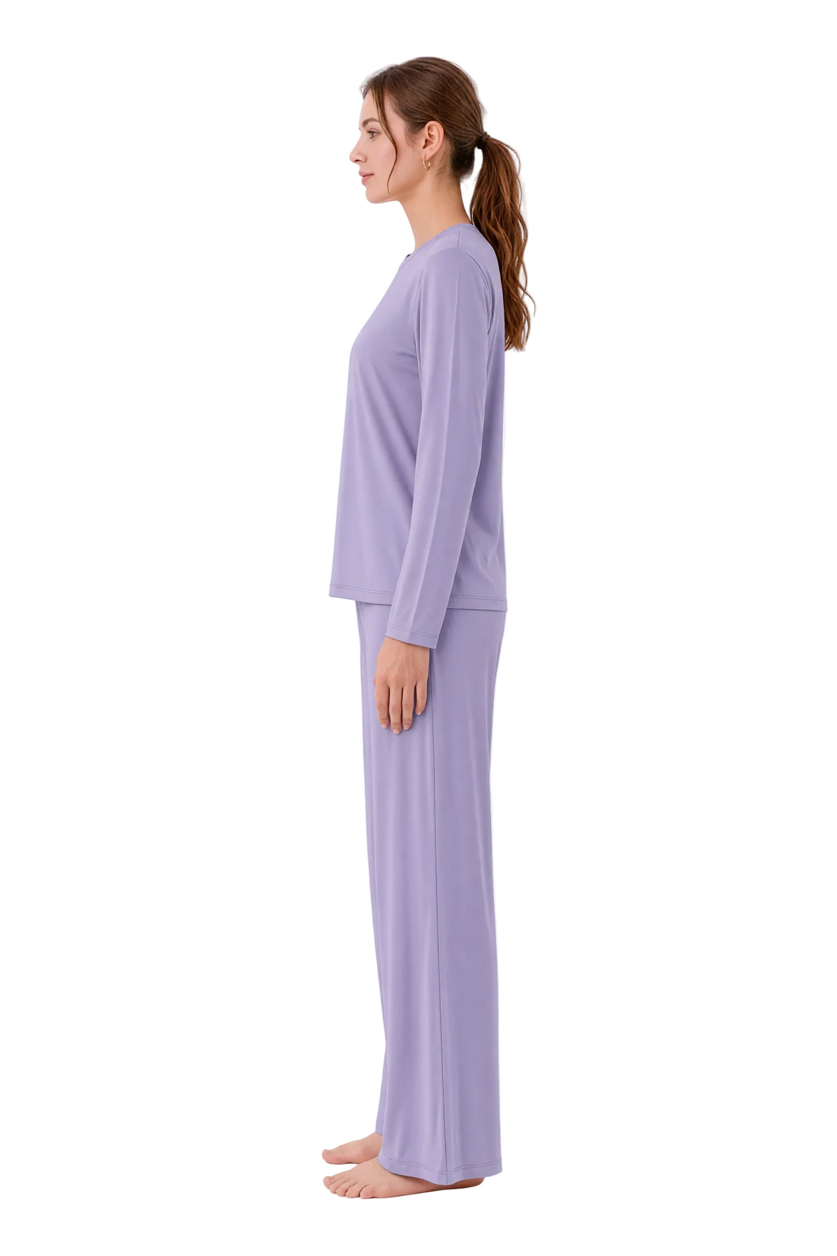 A woman in profile wearing a matching two-piece pajama set in light lavender, standing against a plain white studio background.